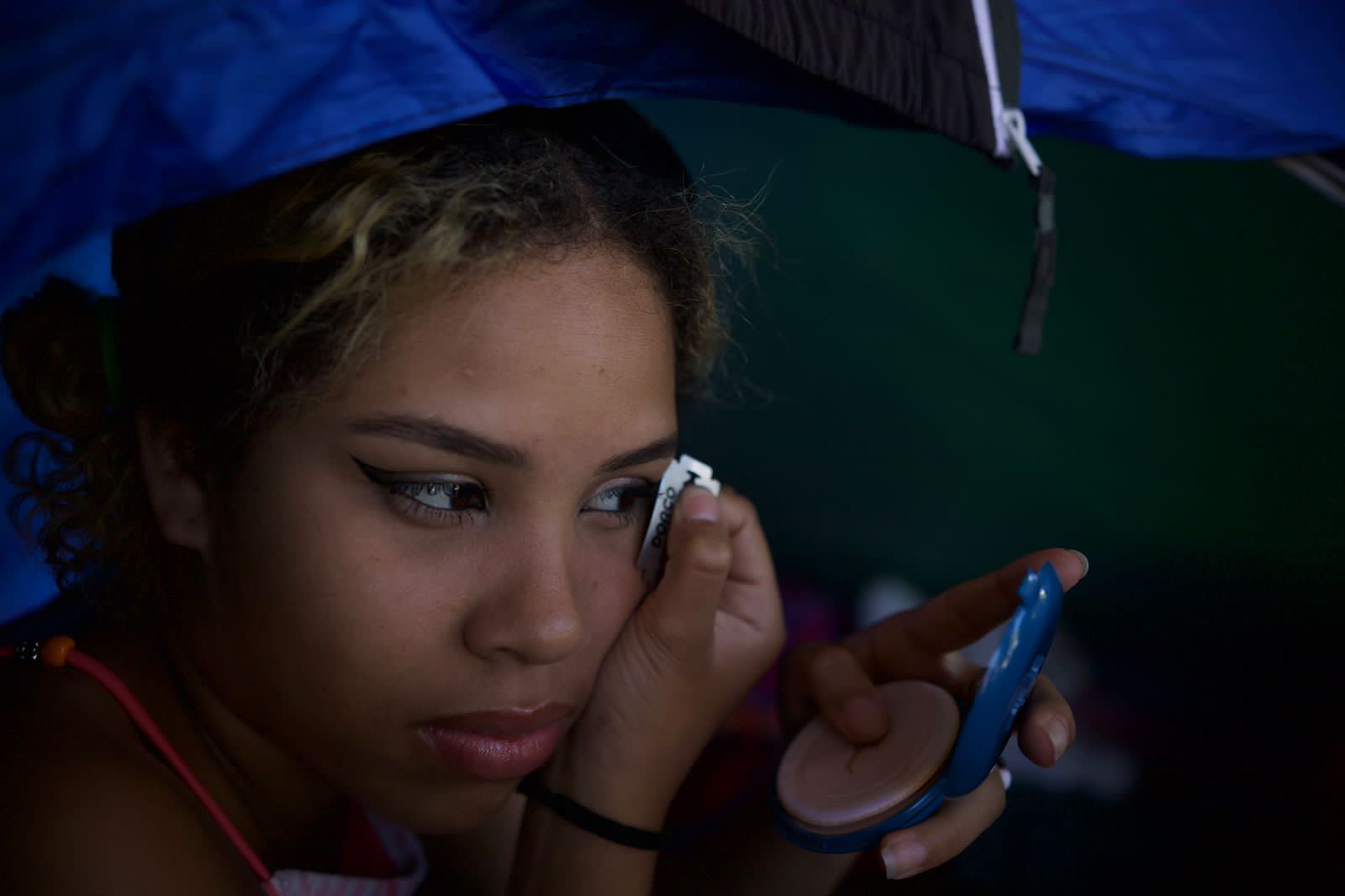 Wisneidi Navas se depila las cejas con una gillette en la estación del Trans-450, mientras espera para poder continuar su viaje. Foto CC / Fernando Destephen.